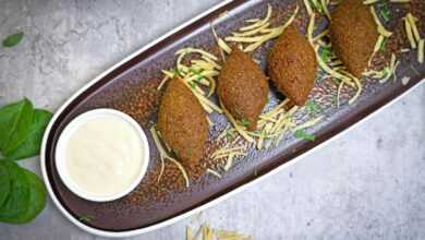 A plate with three meatballs and a dipping sauce