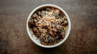 a white bowl filled with food on top of a wooden table