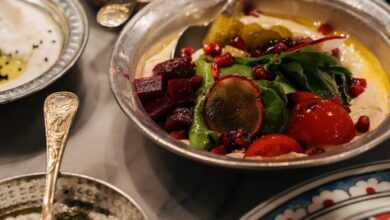 A beautifully arranged Middle Eastern meal featuring vibrant salads and dips in ornate bowls.