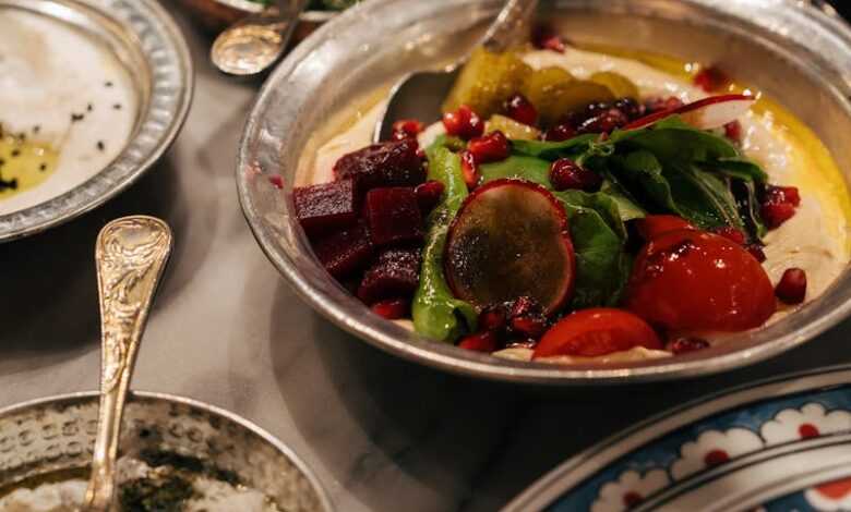 A beautifully arranged Middle Eastern meal featuring vibrant salads and dips in ornate bowls.