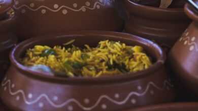 Colorful Indian dishes beautifully presented in clay pots, highlighting traditional cuisine.