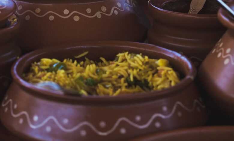 Colorful Indian dishes beautifully presented in clay pots, highlighting traditional cuisine.