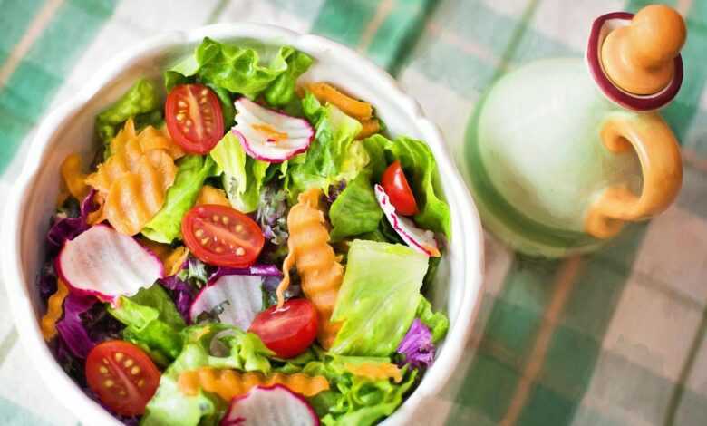 Colorful fresh vegetable salad with cherry tomatoes in a white bowl.