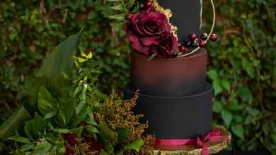 An Artistic Set-up Of A Halloween Decor With Leaves Flowers Skull And a Tier Of Painted Containers