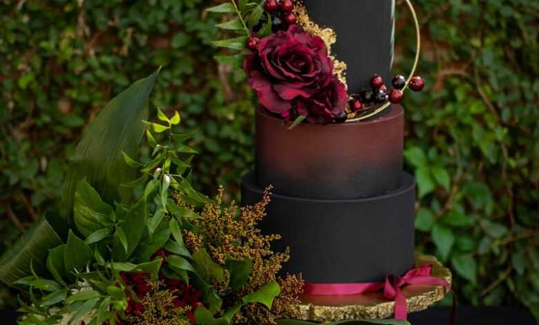 An Artistic Set-up Of A Halloween Decor With Leaves Flowers Skull And a Tier Of Painted Containers