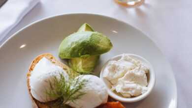 From above of appetizing breakfast with toast and poached eggs served with avocado and glass of orange juice