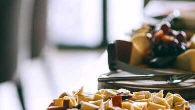 Delicious appetizers served on plates on wooden banquet table in cafeteria in light day