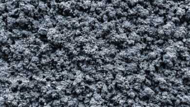 Top view abstract background of textured rough mineral surface of dark gray color