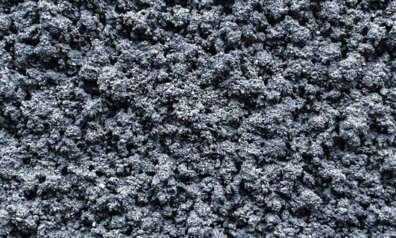 Top view abstract background of textured rough mineral surface of dark gray color