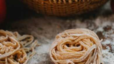 Dough of fresh noodle placed on table near vegetables