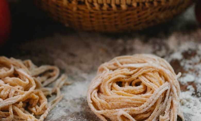 Dough of fresh noodle placed on table near vegetables