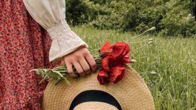 Woman with hat and flowers in field