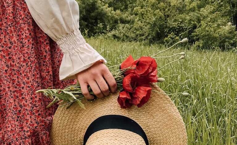 Woman with hat and flowers in field