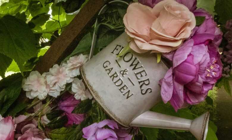 pink and orange flowers on grey watering can