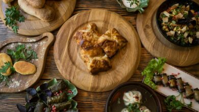 A variety of traditional Georgian dishes displayed on a wooden table with fresh herbs.