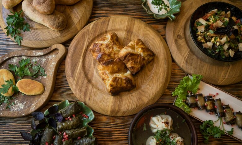 A variety of traditional Georgian dishes displayed on a wooden table with fresh herbs.