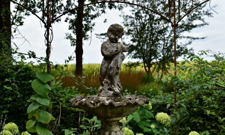 a statue of a person sitting on top of a fountain