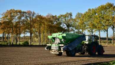 a tractor is driving down a dirt road