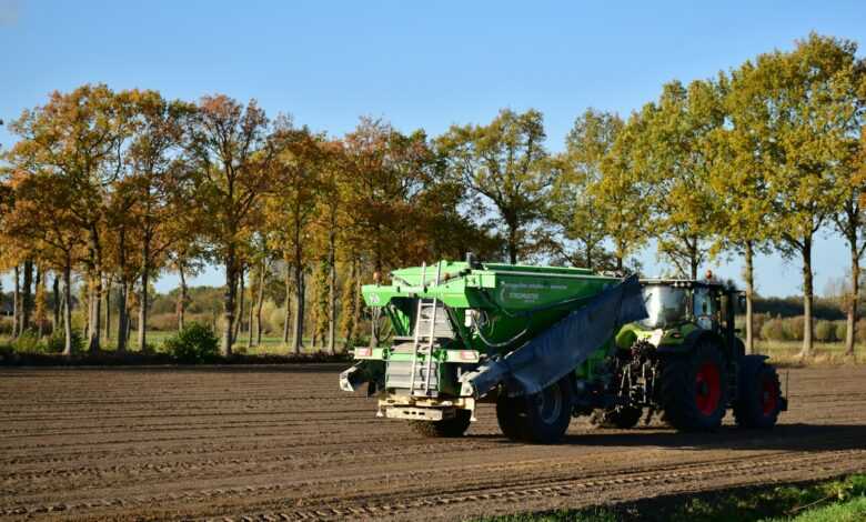 a tractor is driving down a dirt road