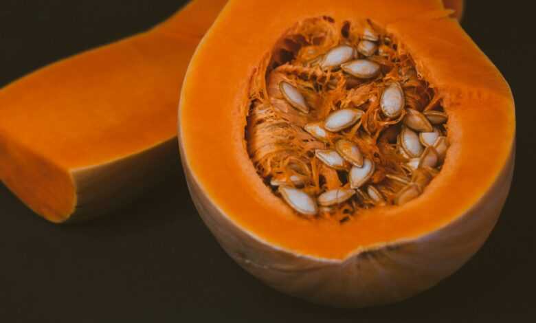 a close up of a pumpkin with seeds inside of it