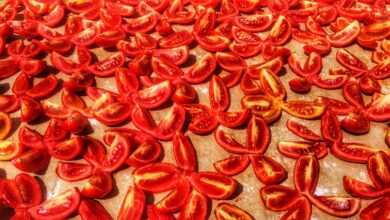 a table topped with sliced tomatoes on top of a wooden cutting board