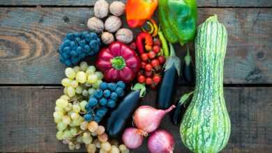 a variety of fruits and vegetables on a wooden surface