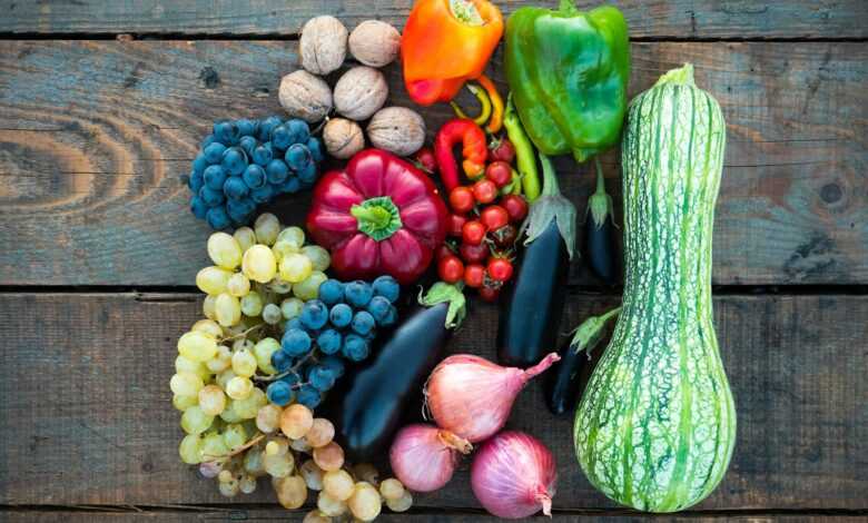 a variety of fruits and vegetables on a wooden surface