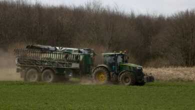 a tractor pulling a trailer behind it in a field