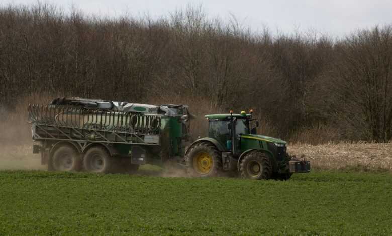 a tractor pulling a trailer behind it in a field