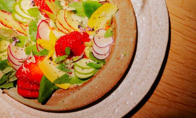 a plate of fruit salad on a wooden table