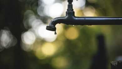 tilt shift lens photography of black steel faucet