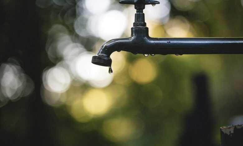 tilt shift lens photography of black steel faucet