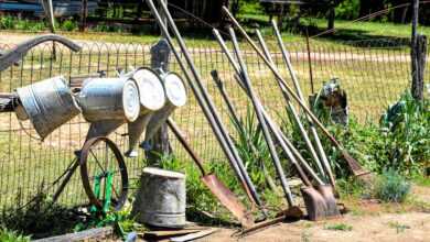 an old fashioned water pump sitting next to a fence