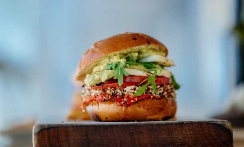 selective focus photography of hamburger with sliced tomatoes and vegetables