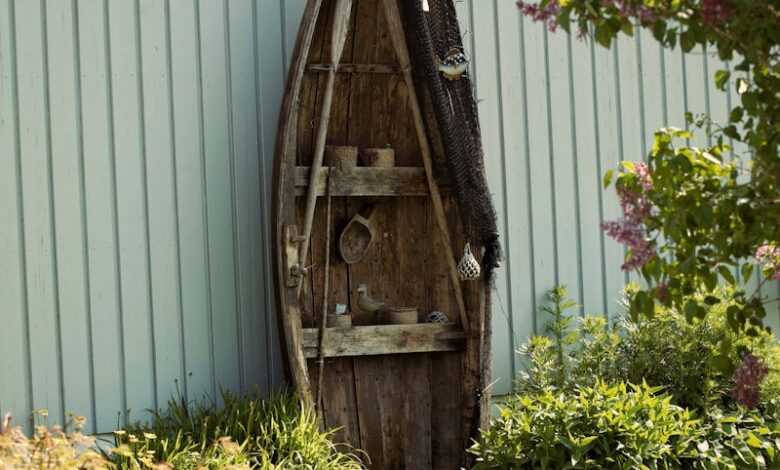 a wooden boat sitting on top of a lush green field