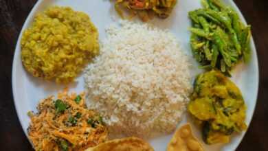 A plate of rice and various south asian dishes.