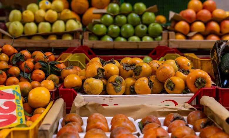 a fruit stand with oranges, apples, and other fruits